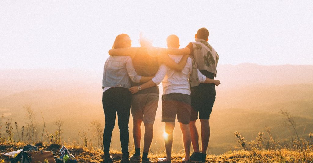 A group of friends embrace while enjoying a breathtaking sunrise over the Brazilian highlands.