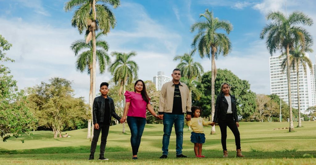 A cheerful family enjoys a sunny day in the park, surrounded by palm trees and lush greenery.